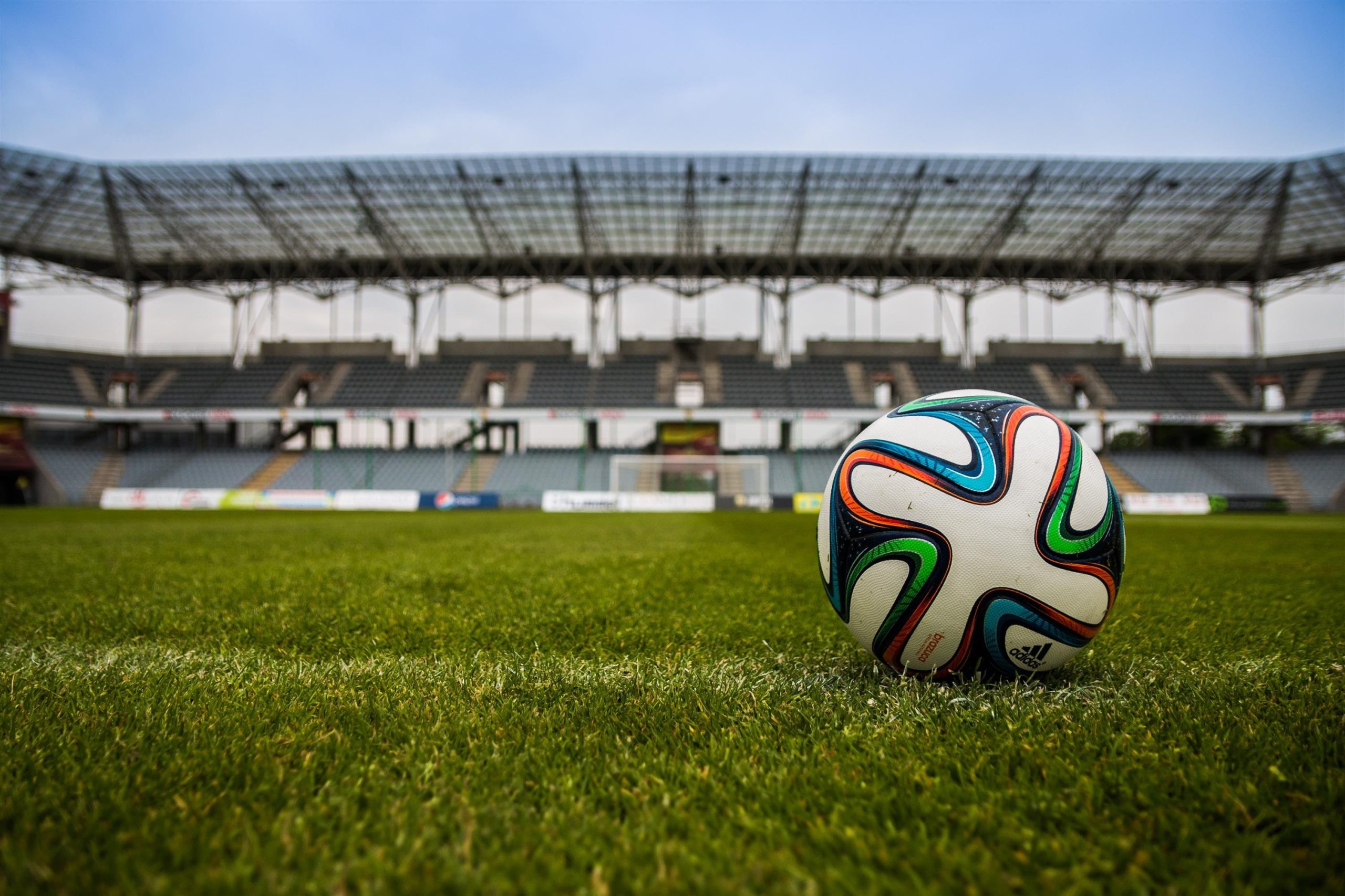 An image showcasing a football kept on a field that is being used as a cover image for a sports management portal case study